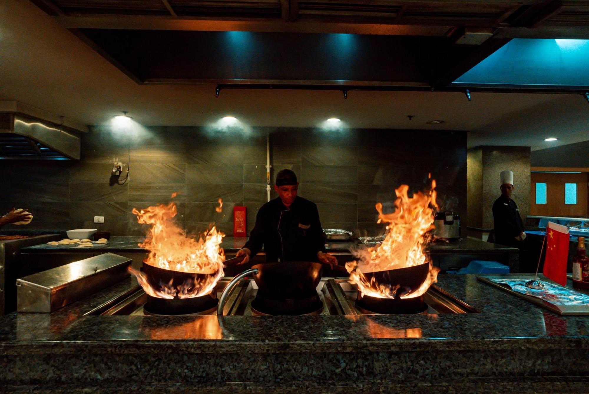 The V Luxury Resort Sahl Hasheesh Hurghada Eksteriør bilde A chef cooking with a wok