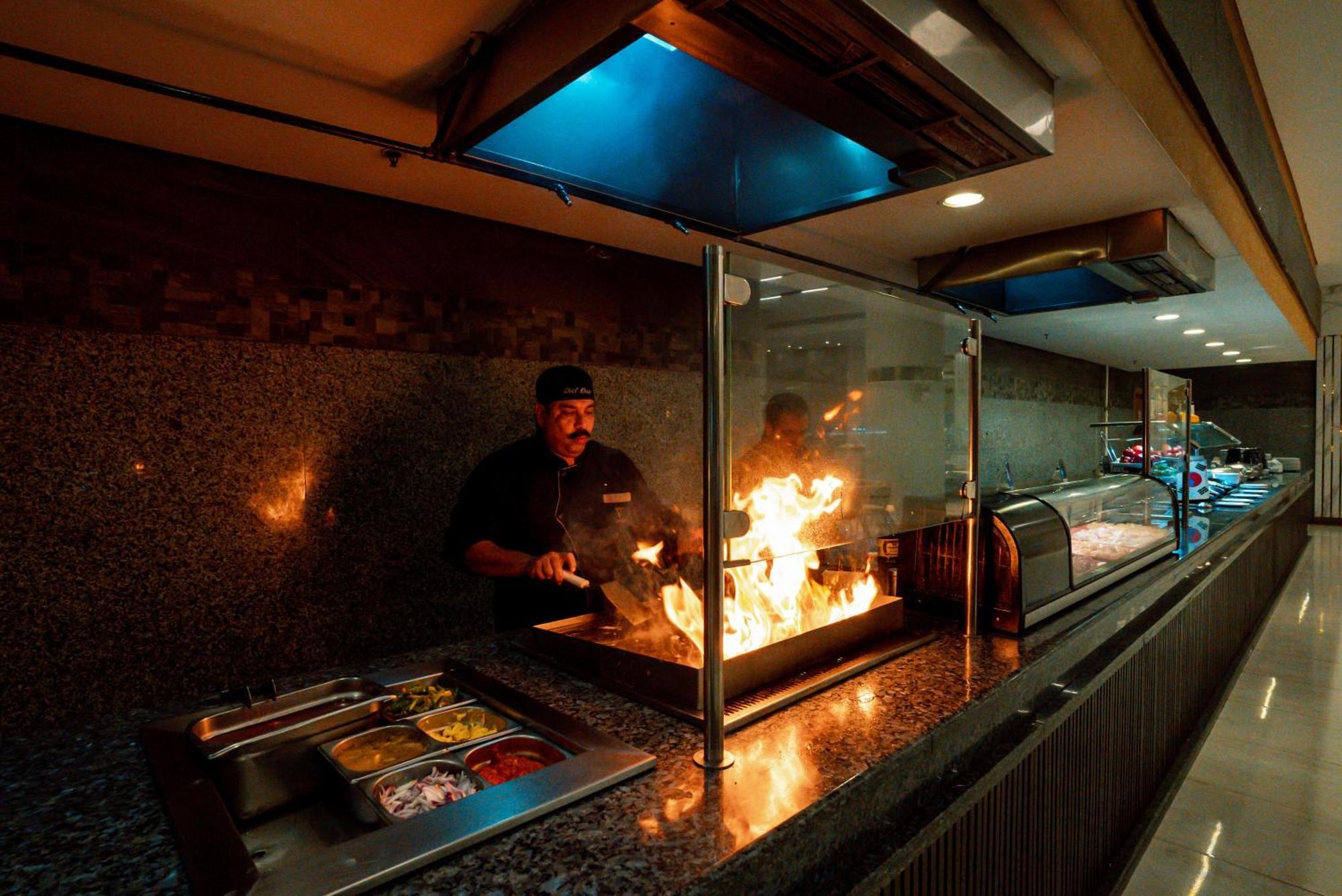 The V Luxury Resort Sahl Hasheesh Hurghada Eksteriør bilde A chef cooking with a flaming torch