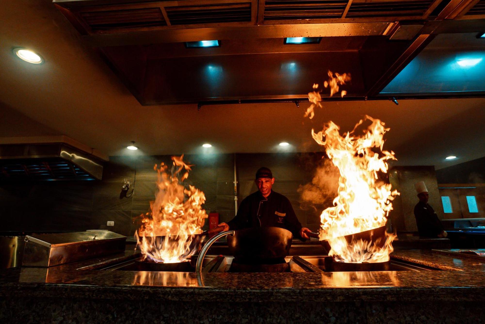 The V Luxury Resort Sahl Hasheesh Hurghada Eksteriør bilde A chef cooking with a wok